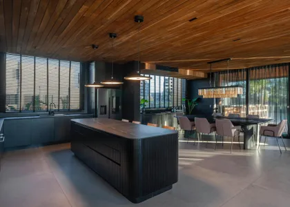 Cocina moderna con isla y techo de madera, iluminación natural abundante — proyecto Muelles - Estudio Pacifica, por ABEJA CONCEPT, en Nordelta